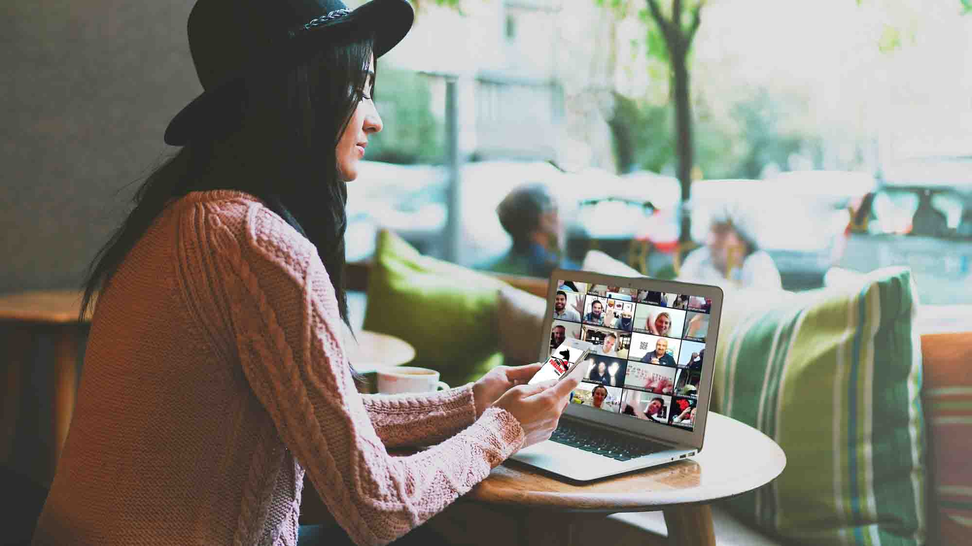 Young professional freelancer working on a new project, searching information in the web on a portable computer and a tablet. Beautiful girl in a hat sitting beside the laptop with white blank monitor