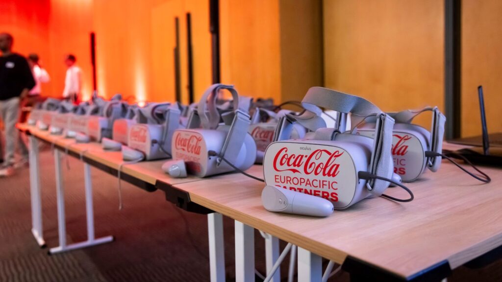 Row of branded VR headsets lined up on a conference table, ready for participants.